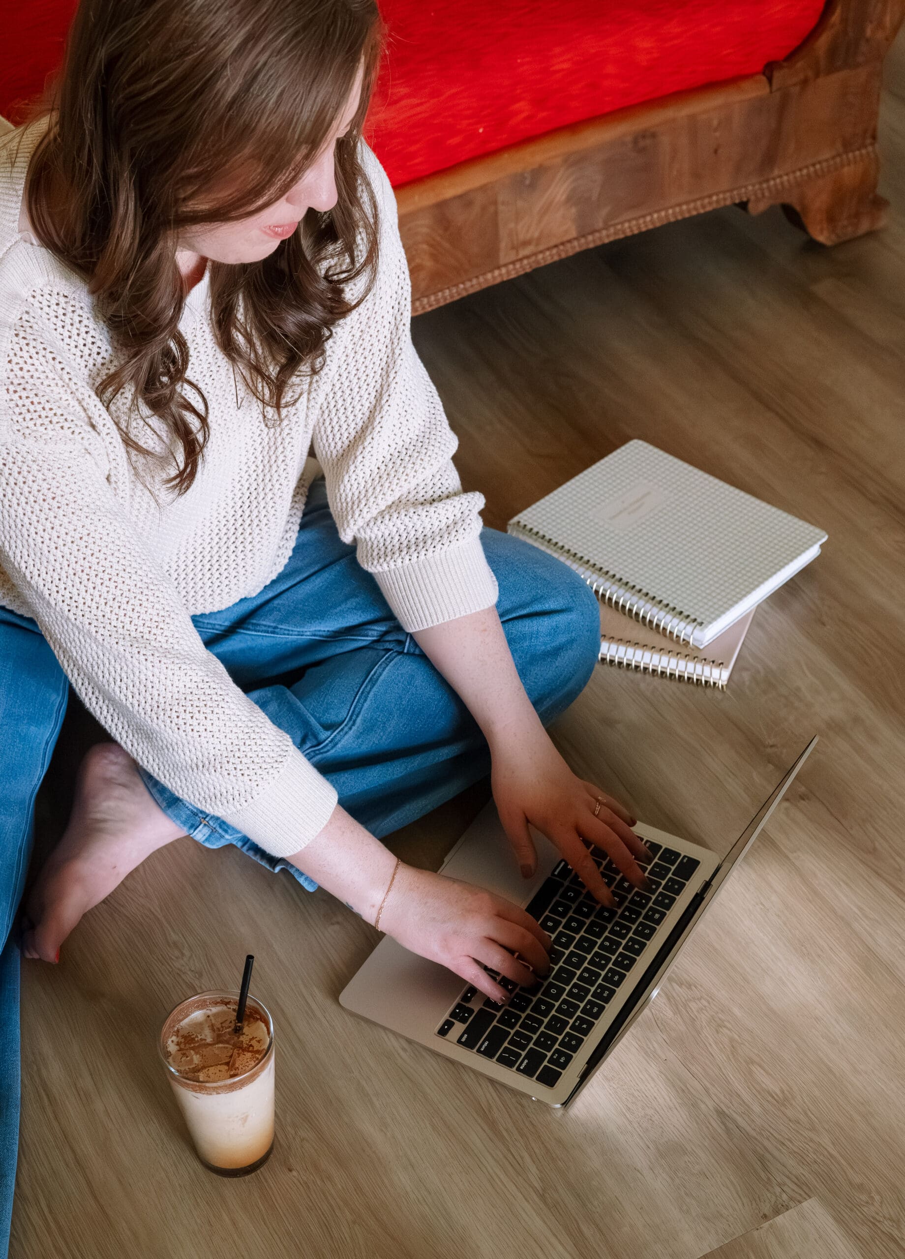 an online business manager for founders with adhd types on a computer with a cup of coffee and a notebook